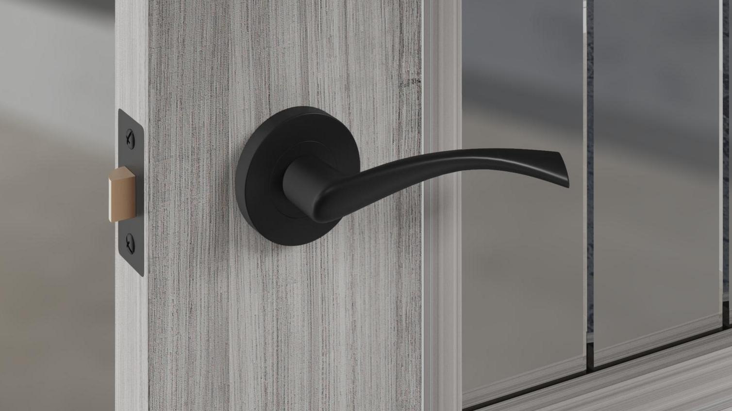 A black curved door handle on a grained, grey door.