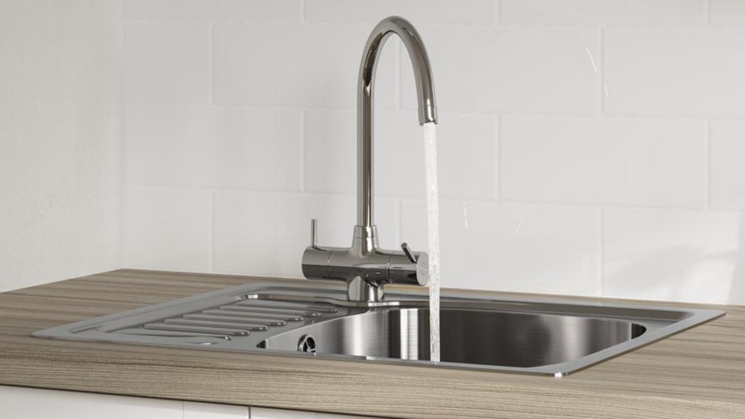 A Howdens chrome sink and tap pack in a wood-effect worktop