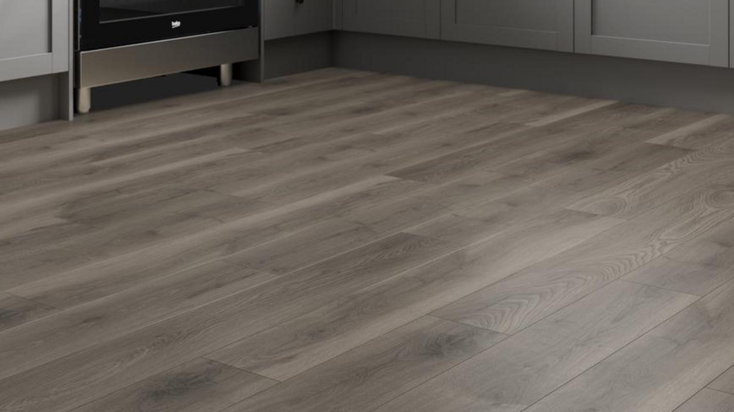 A utility room with dark brown, timber-effect laminate flooring
