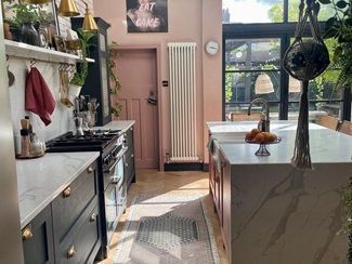 A layered kitchen in pink, navy and marbled grey