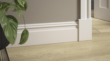 A doorway with laminate timber floorboards and elmbridge skirting