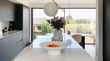 Black handleless kitchen design with a matt finish and luxury style using marble-effect quartz counters