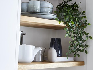 open shelving used in a small white kitchen to provide storage using wooden worktops