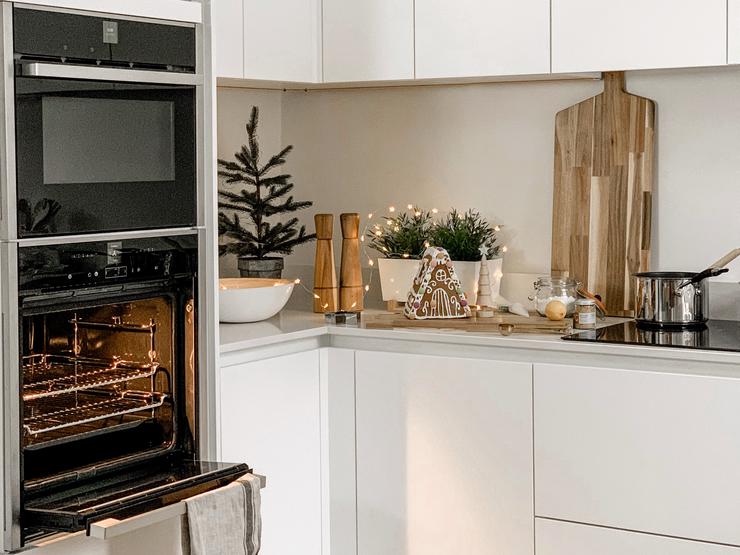 a white handleless kitchen at Christmas with a built in oven and microwave.
