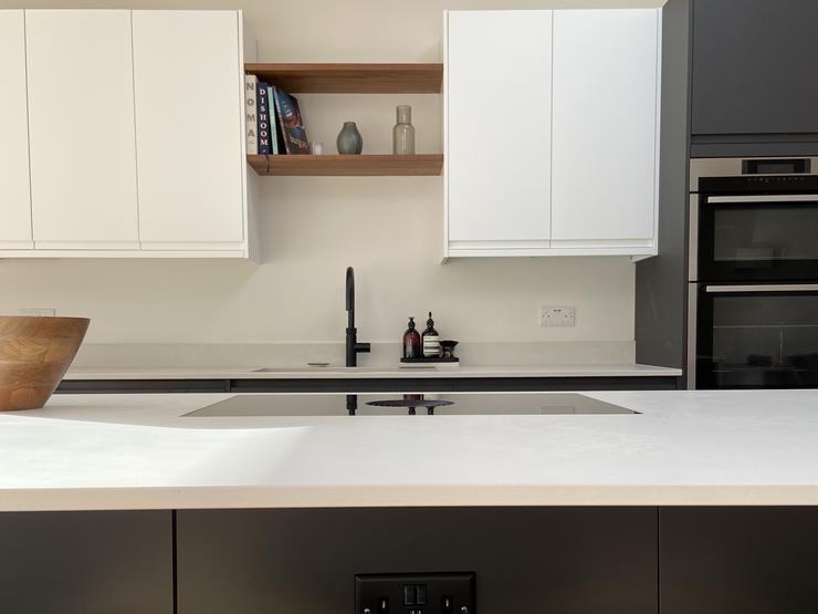 Kitchen island with white worktop and dark charcoal units