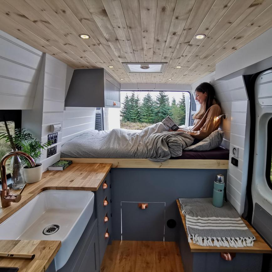 Campervan interior with Fairford blue kitchen units and bed