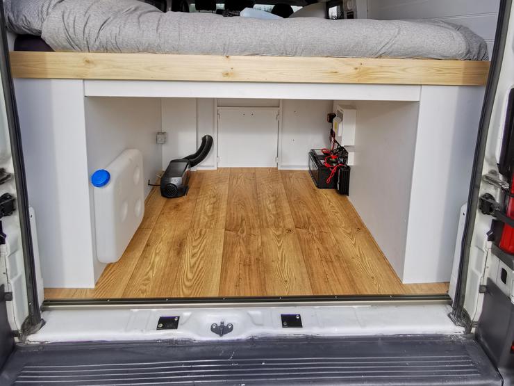 Campervan interior with under-bed devices and storage
