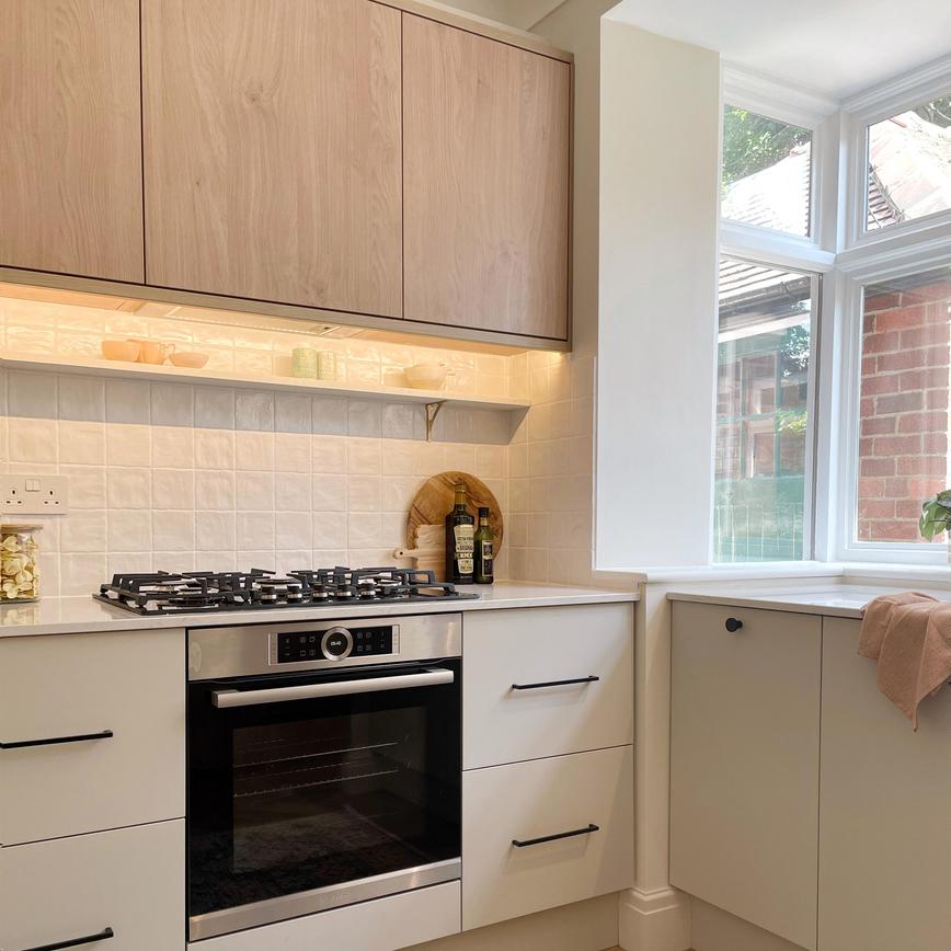 Two-tone kitchen with oak wall cupboards and cream floor units