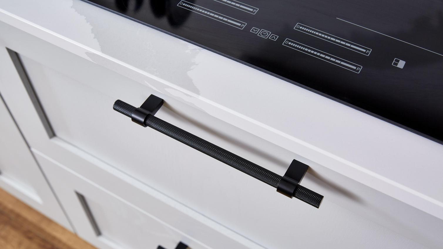 Knurled bar handles in black fitted onto wide pan drawers with shaker cupboard doors