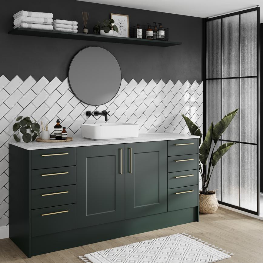 Compact green bathroom featuring shaker cupboards with a matt finish. Has brass handles, a white worktop, and an oak floor.