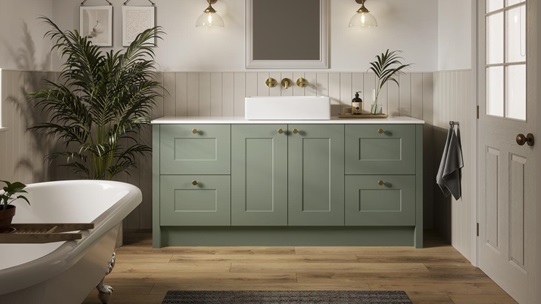 A Chelford reed green bathroom with shaker cabinets and vanity unit. Also includes oak-style flooring and roll top bath.
