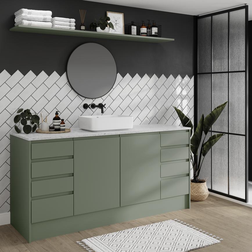 A Clerkenwell bathroom with green cabinets, marble worktop, and black accessories. Also features grey oak flooring.