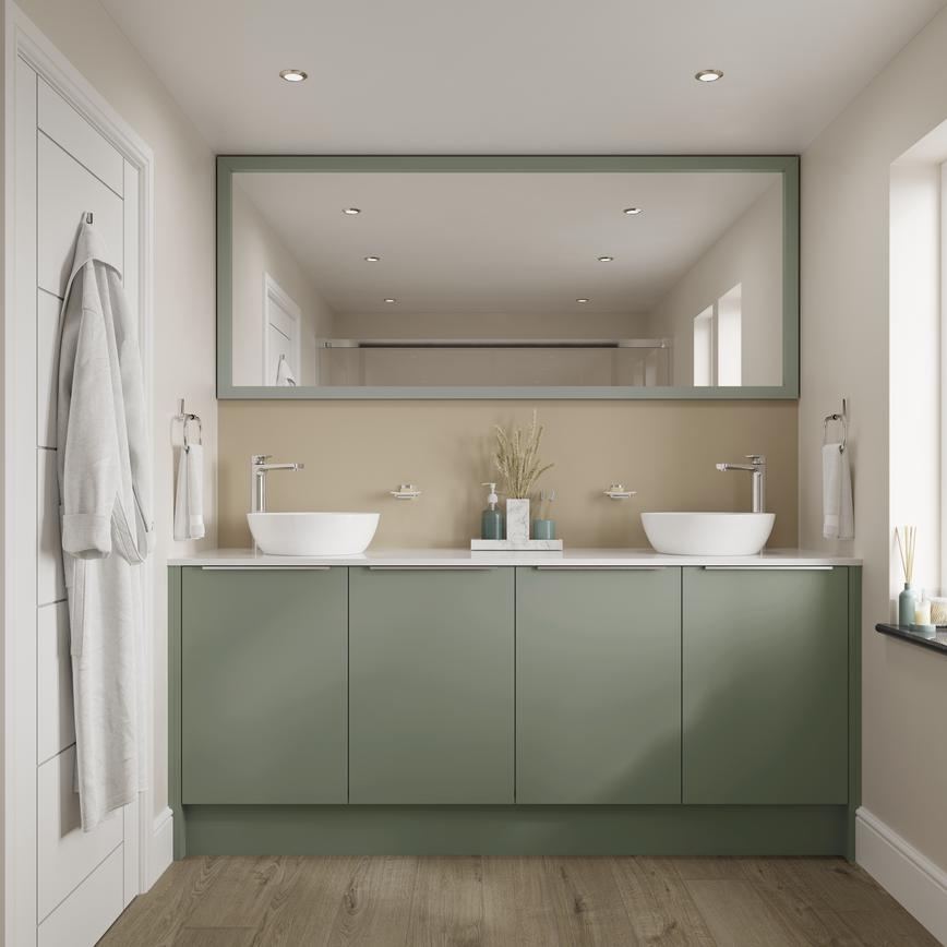A small Greenwich bathroom with green cabinets, two sinks, and a large mirror. Bathroom features chrome taps and oak flooring.