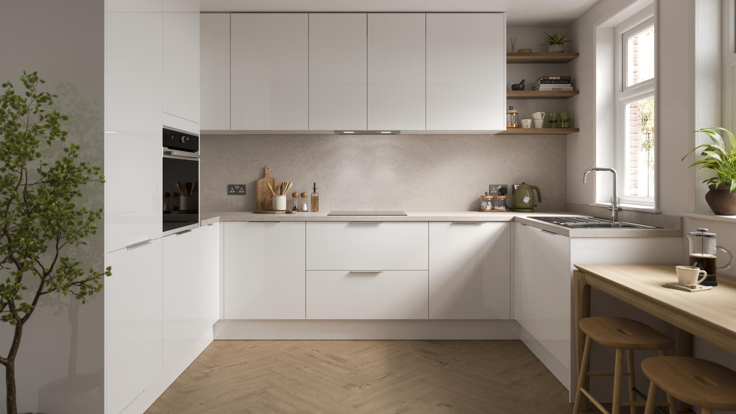 A gloss white kitchen from the Greenwich range, in a U-shaped layout with integrated appliances and matching wall cabinets.