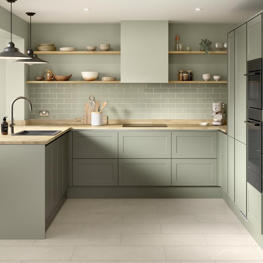 A reed green, modern shaker kitchen from the Frome handleless collection. It has a timber worktop and a u-shaped layout