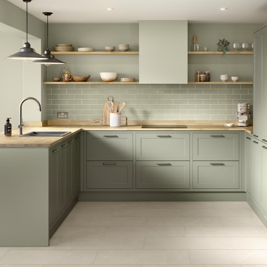 A modern shaker kitchen from the Frome in frame collection. It has a reed green tone, timber worktops, and u-shaped layout.