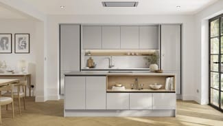 A gloss, dove grey kitchen with handleless cabinets and black trim. It is in an island layout with oak herringbone flooring