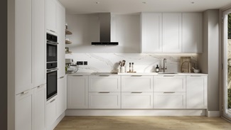 A modern, white shaker kitchen in an l-shaped layout, with tower and wall cabinets. It also has light oak-effect flooring.
