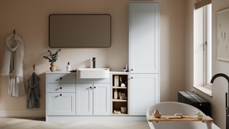 A mist-blue bathroom with shaker vanity unit & matching tall storage cabinet. It has white fittings with black accessories.