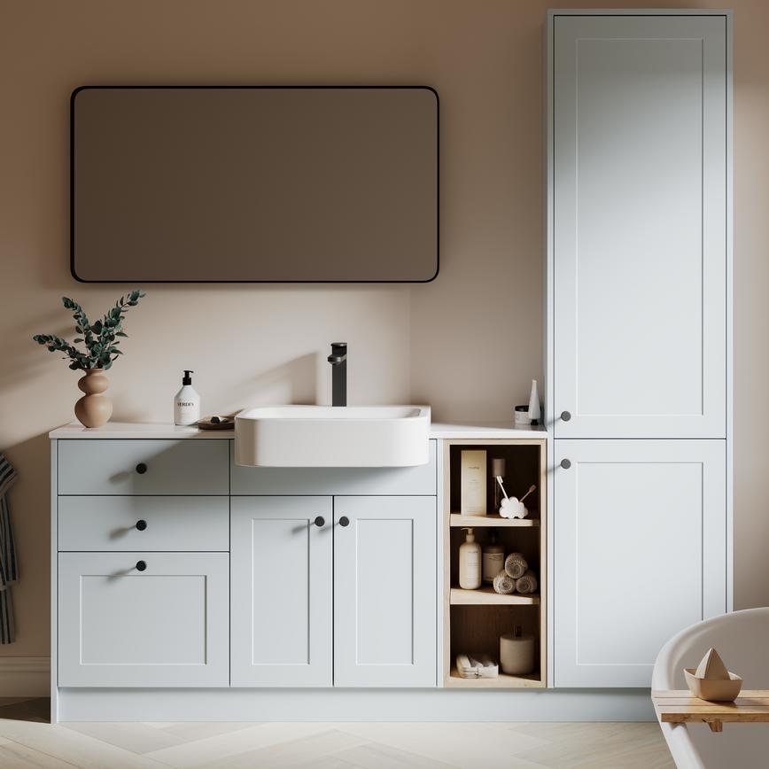 A mist-blue bathroom with shaker vanity unit & matching tall storage cabinet. It has white fittings with black accessories. 