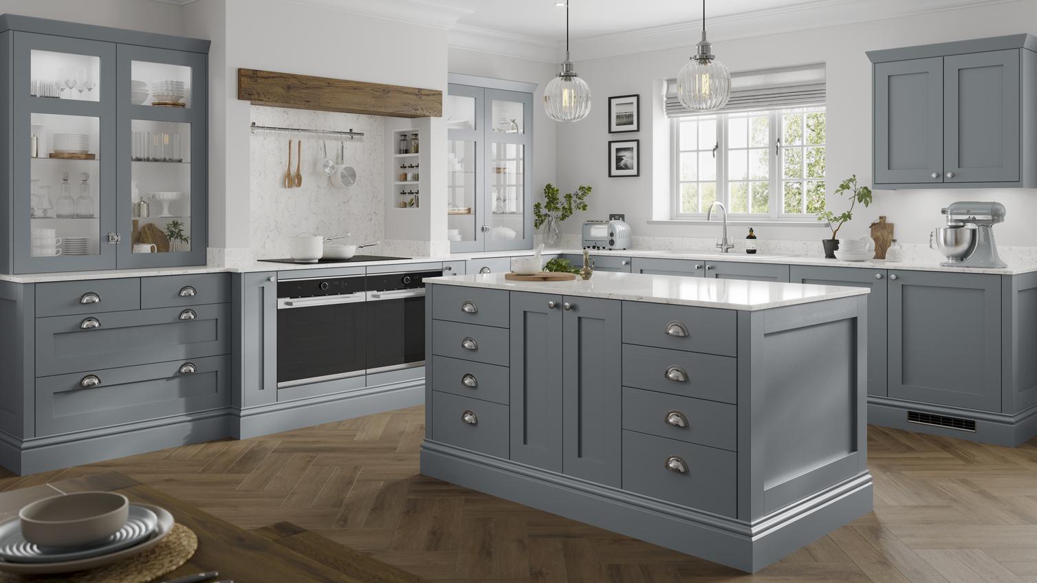 A blue shaker kitchen idea in an L-shaped layout with island. Includes white worktops, glass cabinets, and chrome handles.