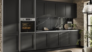 Modern black shaker kitchen featuring handleless doors in a single-wall layout, with a matching black worktop and splashback.