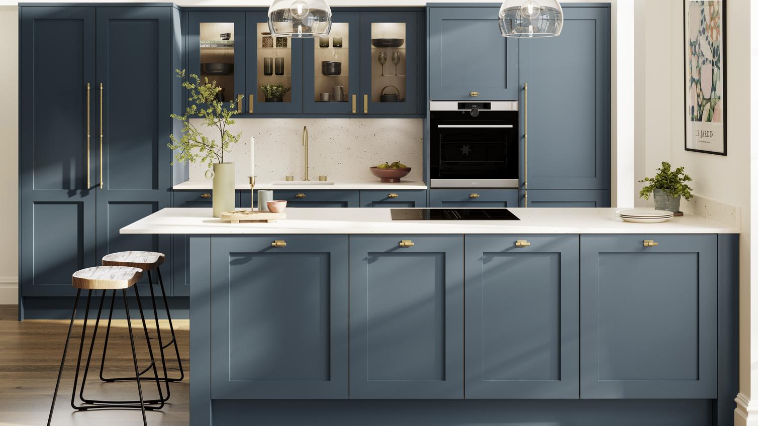 A timeless blue kitchen with shaker cupboard doors, white worktops, wooden floors, and brass knobs in a peninsula layout.
