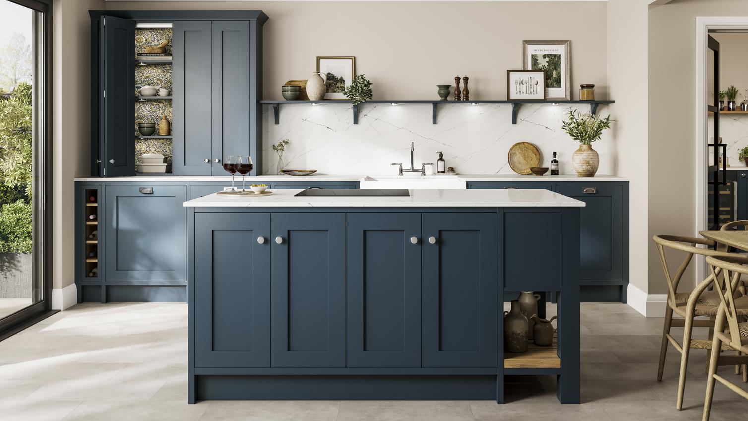 A classic kitchen with in-frame, blue shaker doors, white worktops, chrome knobs, and a black hob in an island layout. 