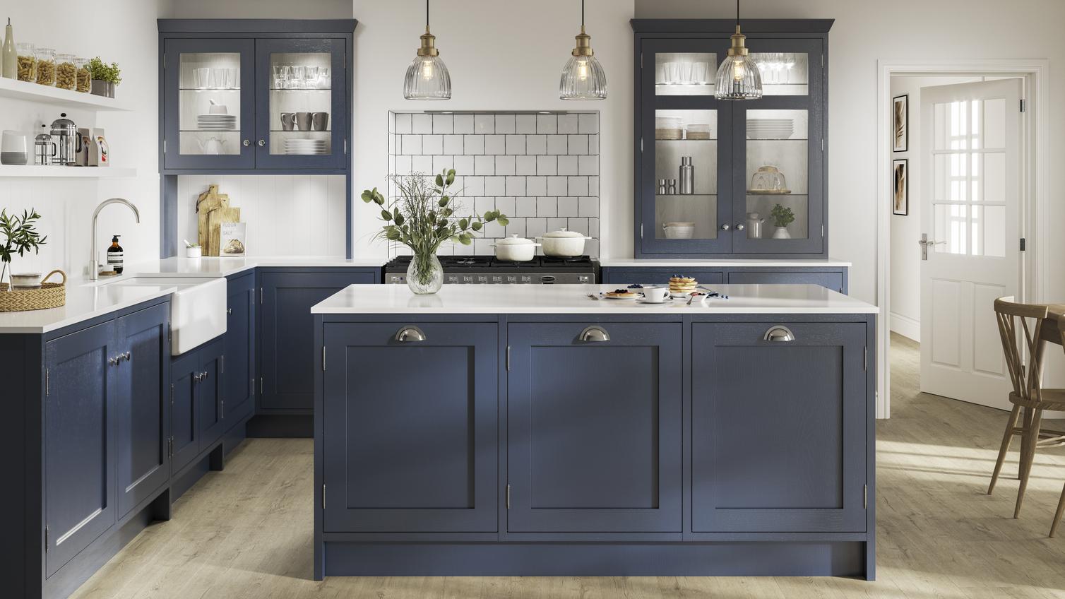 Navy blue shaker kitchen with in-frame profiles in an island layout. Has white worktops, knurled handles, and glass units.
