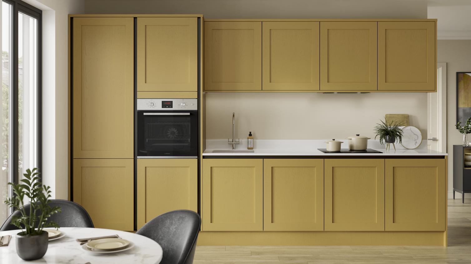 A handleless painted shaker kitchen in mustard yellow with black profiles. Includes white worktops and pale timber floors.