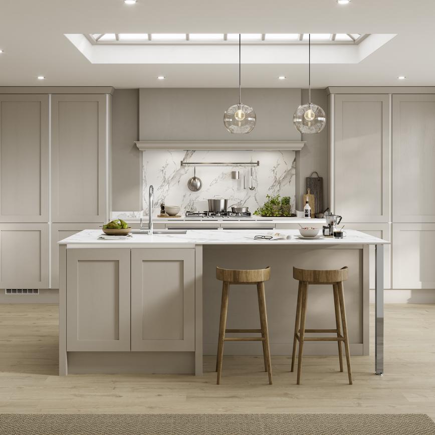 Beige shaker kitchen in an island layout, with white worktops, a chrome tap, and silver trims for a sleek handleless look.