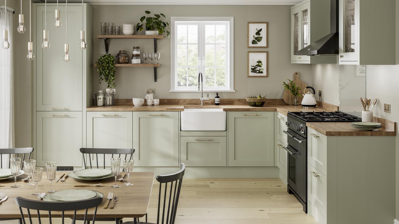 Sage green kitchen idea with shaker doors. Includes a Belfast sink, wood worktops, black extractor and black range cooker.