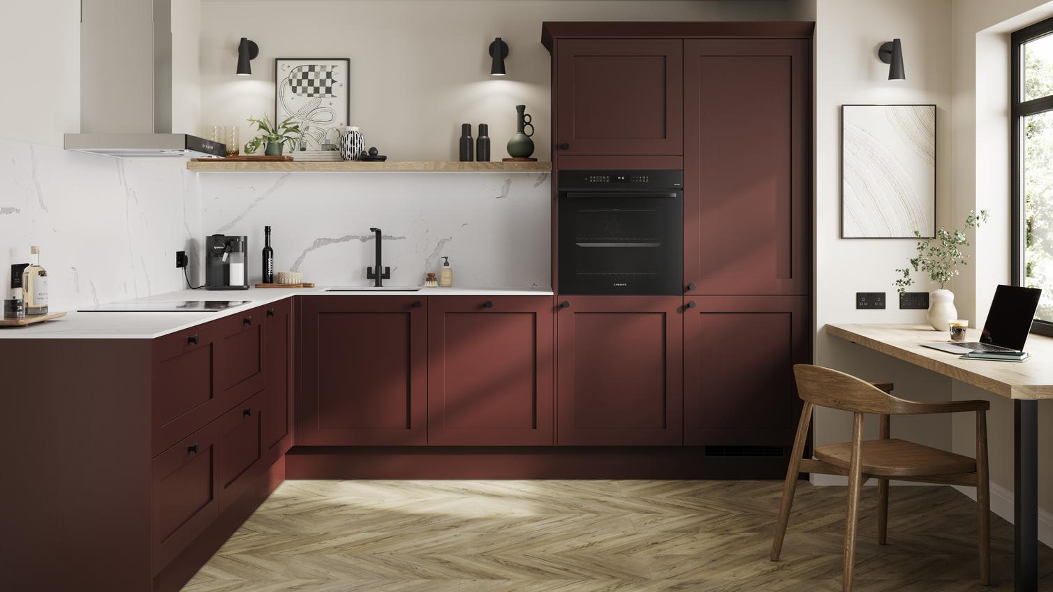 A garnet red shaker kitchen in an L-shaped layout. There are white worktops, oak laminate flooring and undermounted sink.