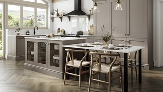 A mushroom brown, L-shaped shaker kitchen with an island. There are white worktops and three glass cabinets in the island.