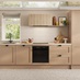 A shaker terracotta kitchen from the Chilcomb collection. It is in a single-wall layout and has rounded black handles.