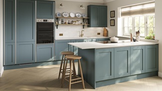 Blue shaker cupboard doors with silver profiles for a classic scheme. Has white worktops and wood flooring for a costal look.