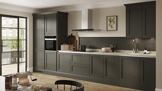 A modern shaker kitchen idea with handleless green cupboard doors. Includes silver metal profiles and a built-in, black oven.