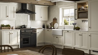 Rustic kitchen design with cream beaded shaker doors in an l-shape layout. Has a black range cooker and white Belfast sink.