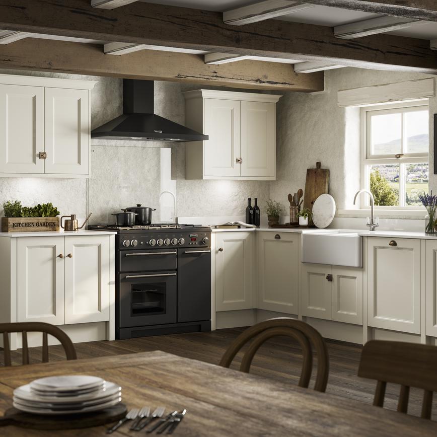 Rustic kitchen design with cream beaded shaker doors in an l-shape layout. Has a black range cooker and white Belfast sink.