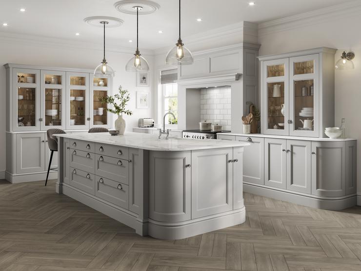 A stately kitchen featuring light-grey shaker doors with a beaded detail and glass dresser cabinets in an island layout.