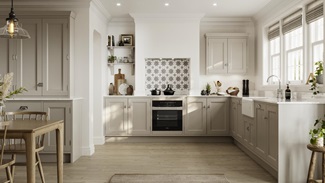 Cream in-frame shaker kitchen in an l-shape layout. Includes white worktops, a butler sink, and chrome decorative hinges.