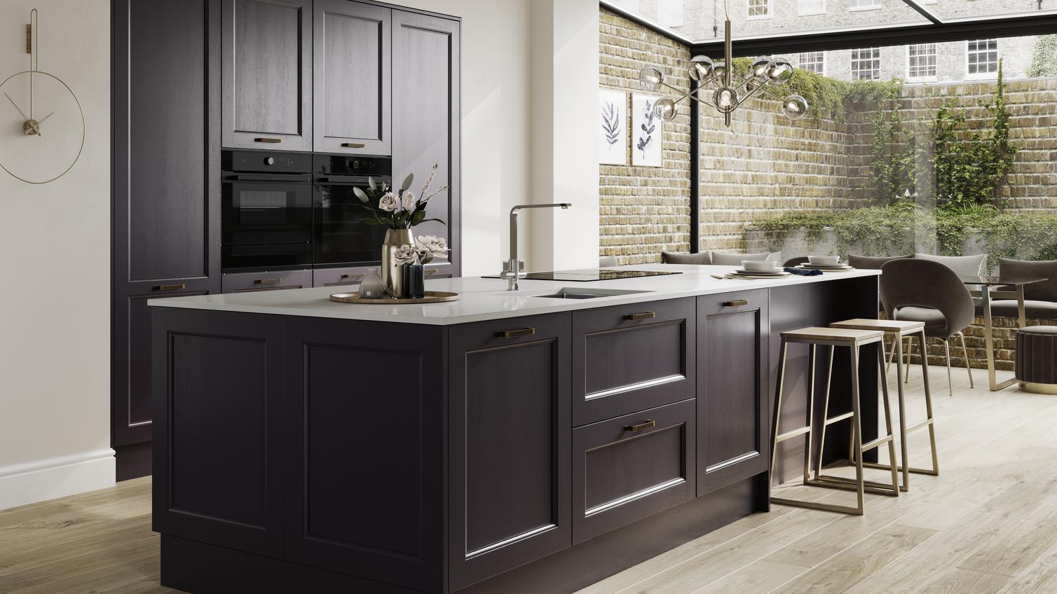 A blackberry purple shaker kitchen in an island layout. It has integrated appliances, a white worktop and brass accessories.
