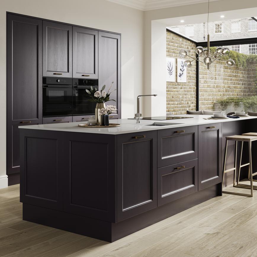 A blackberry purple shaker kitchen in an island layout. It has integrated appliances, a white worktop and brass accessories.