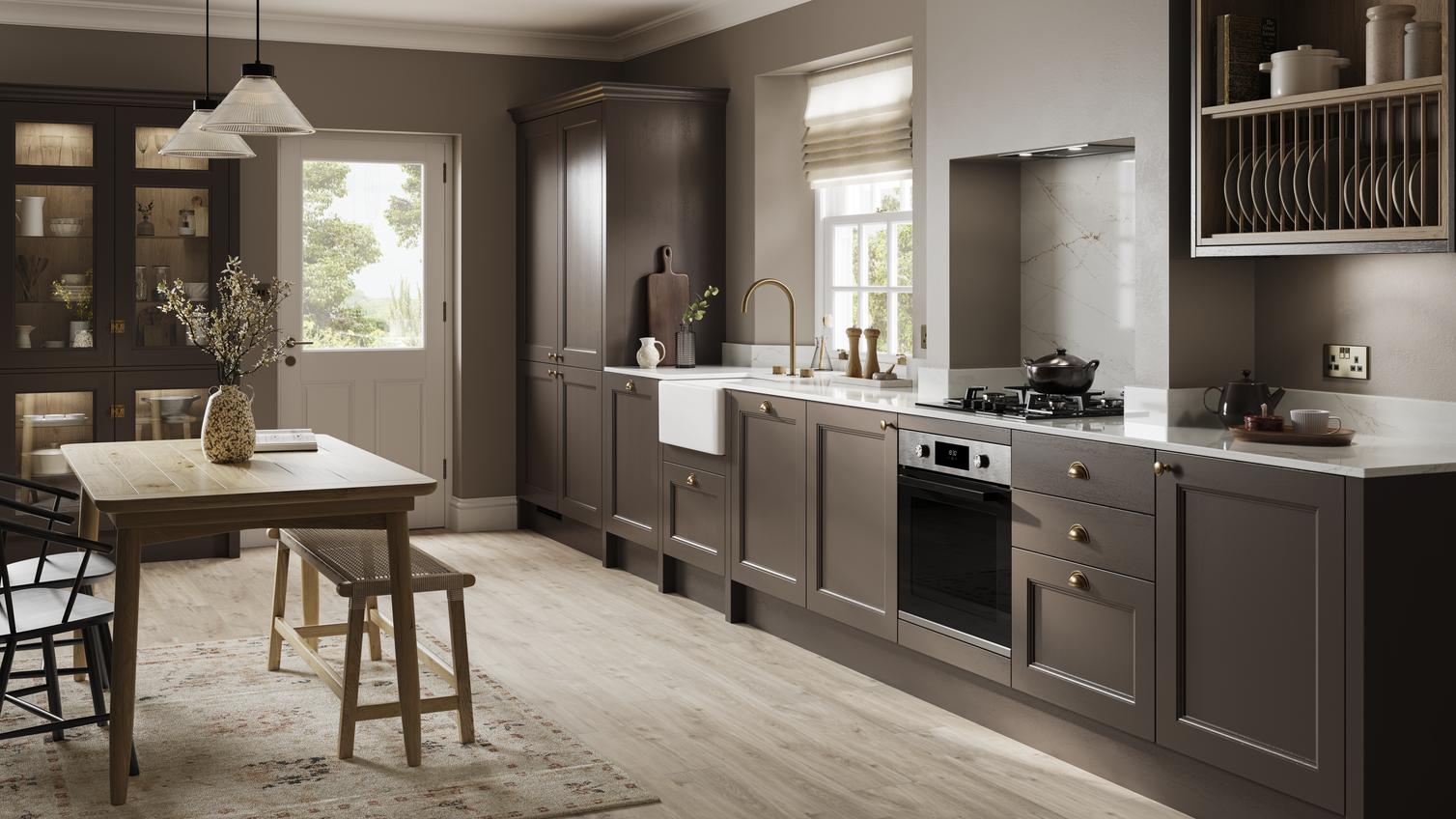 A truffle-brown shaker kitchen in a single wall layout. It has a glass dresser cabinet, white worktops, and wood flooring.