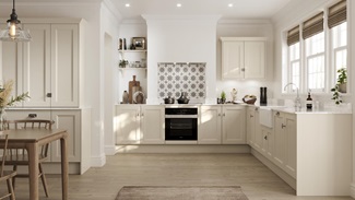 A cream, Linen kitchen in an L-shaped layout and dresser unit in dining area. It has oak-style flooring and a Butler sink.