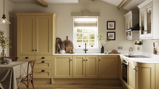 A saffron yellow shaker kitchen in an L-shaped layout, with single-plank flooring. The worktops and wall cabinets are white