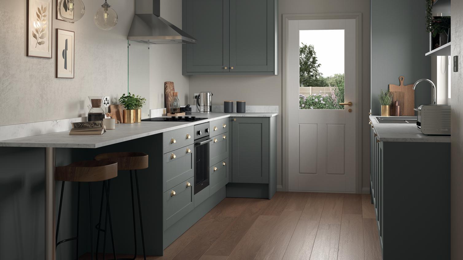 Compact grey kitchen in a galley layout. Features shaker doors, white worktops, and brass cup handles for a stately look