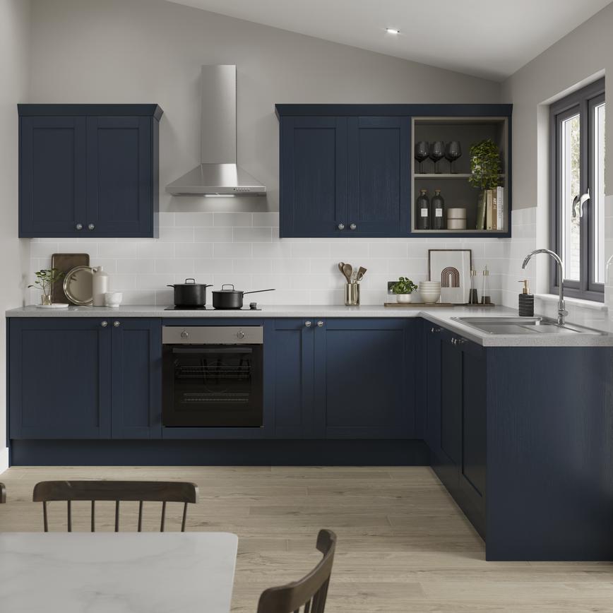 A navy kitchen in an L-shaped layout with shaker cabinets. Includes pale wood floors, grey worktops, and a chimney extractor.