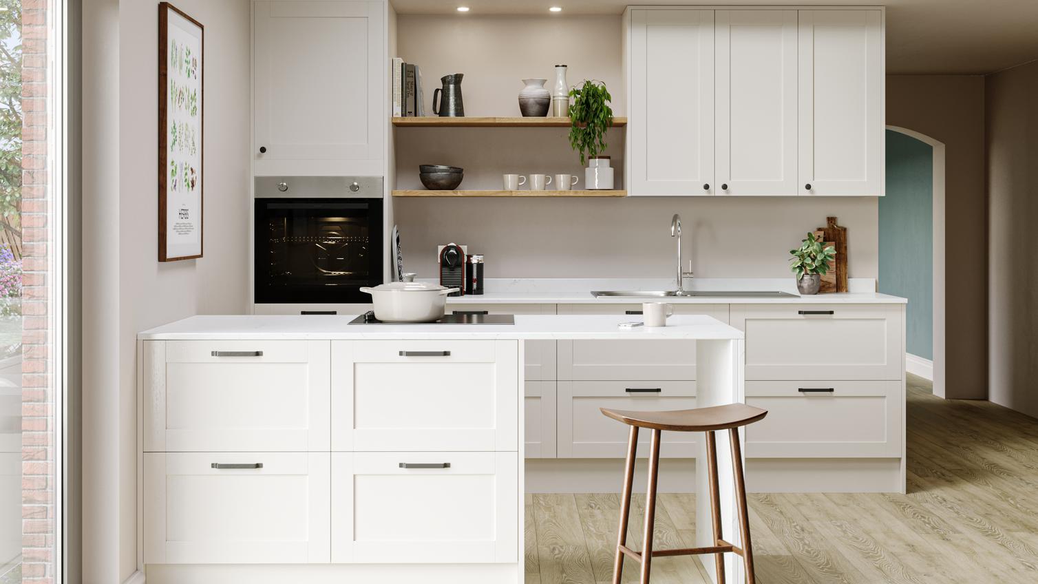 Subtle cream kitchen idea using antique white shaker doors and white worktops. Has a peninsular layout and a breakfast bar.
