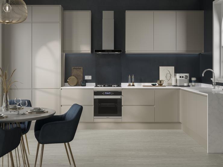 Modern pebble grey handleless kitchen with contrasting dark grey walls and white marble worktop and built under oven.